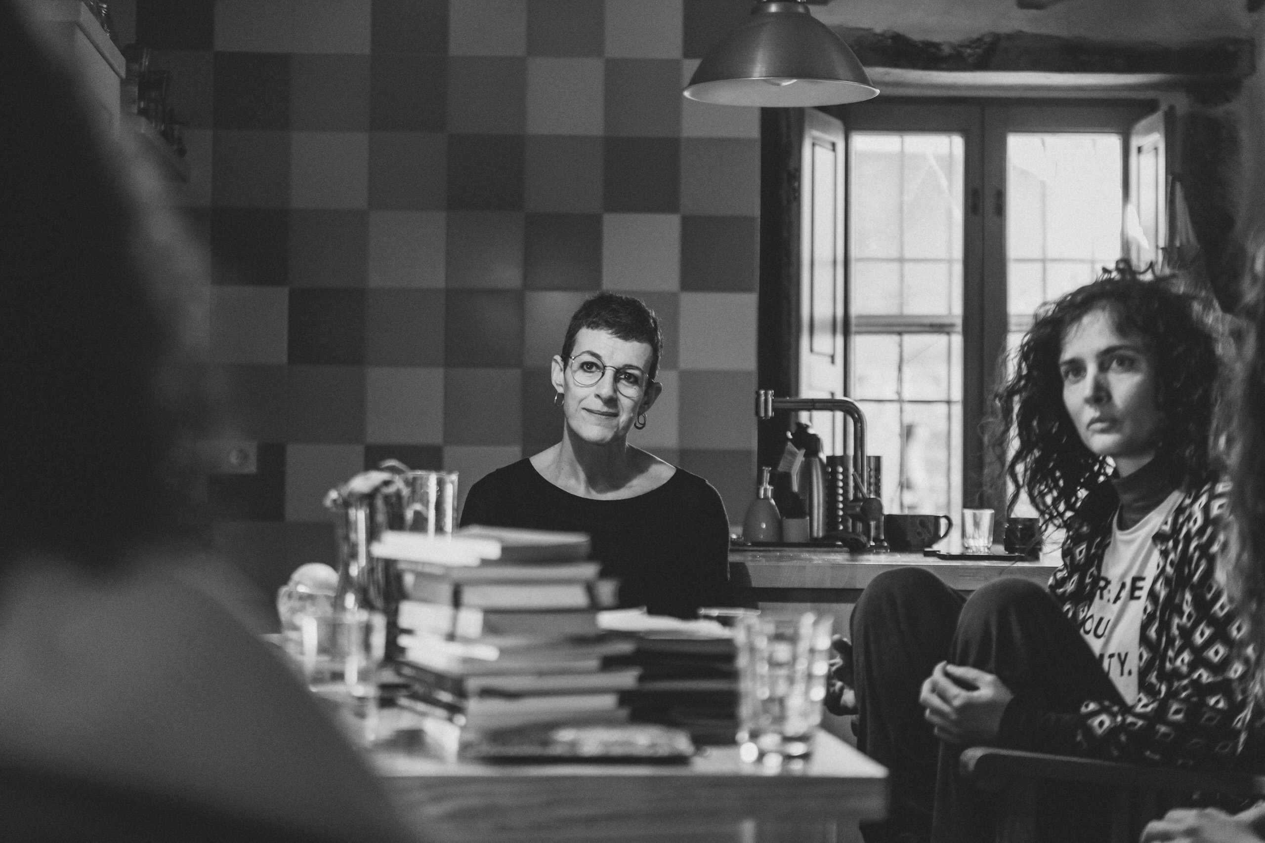 Personas escuchando en un encuentro literario en un espacio interior acogedor