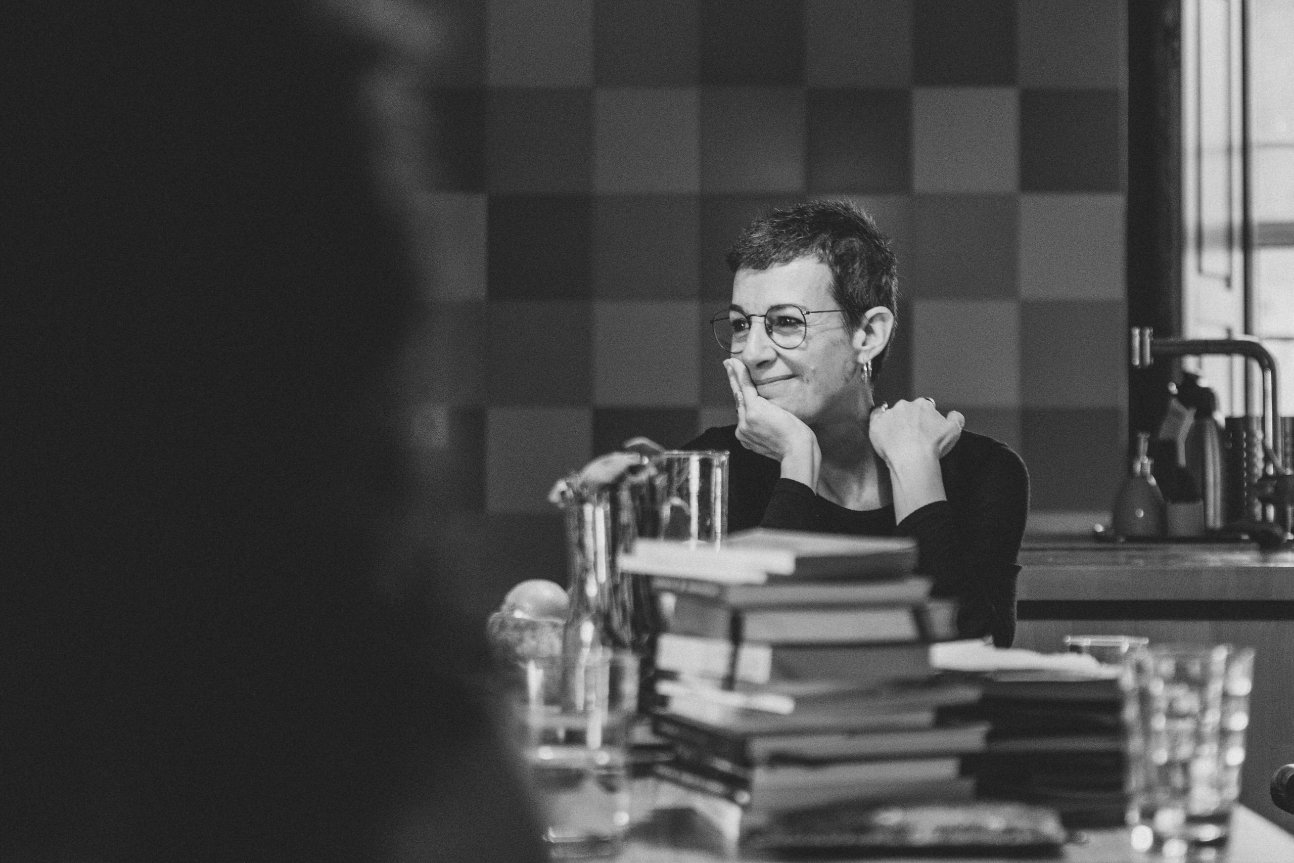 Persona sonriendo y escuchando durante un encuentro literario en interior