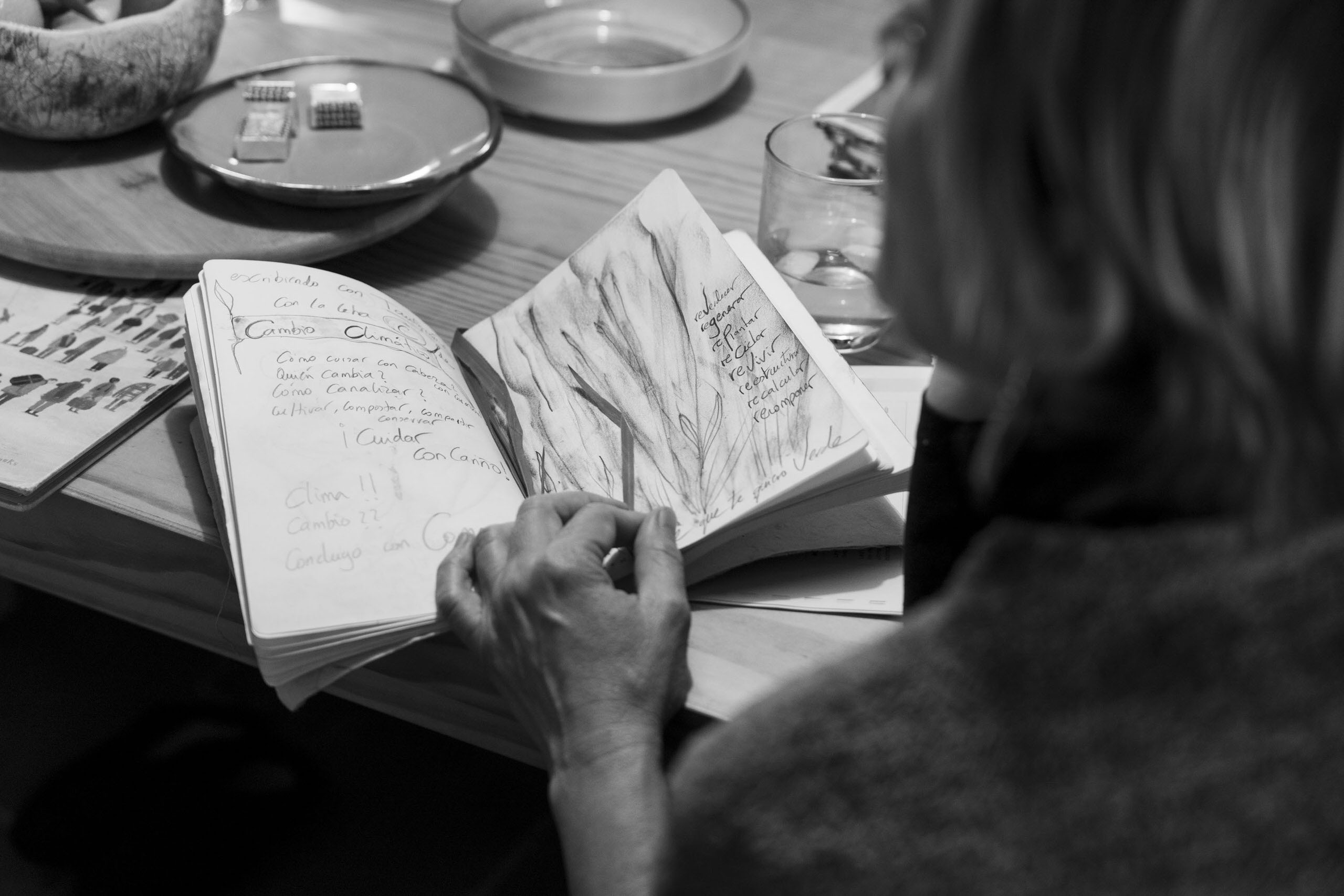 Persona escribiendo y dibujando en cuaderno durante proceso de escritura creativa