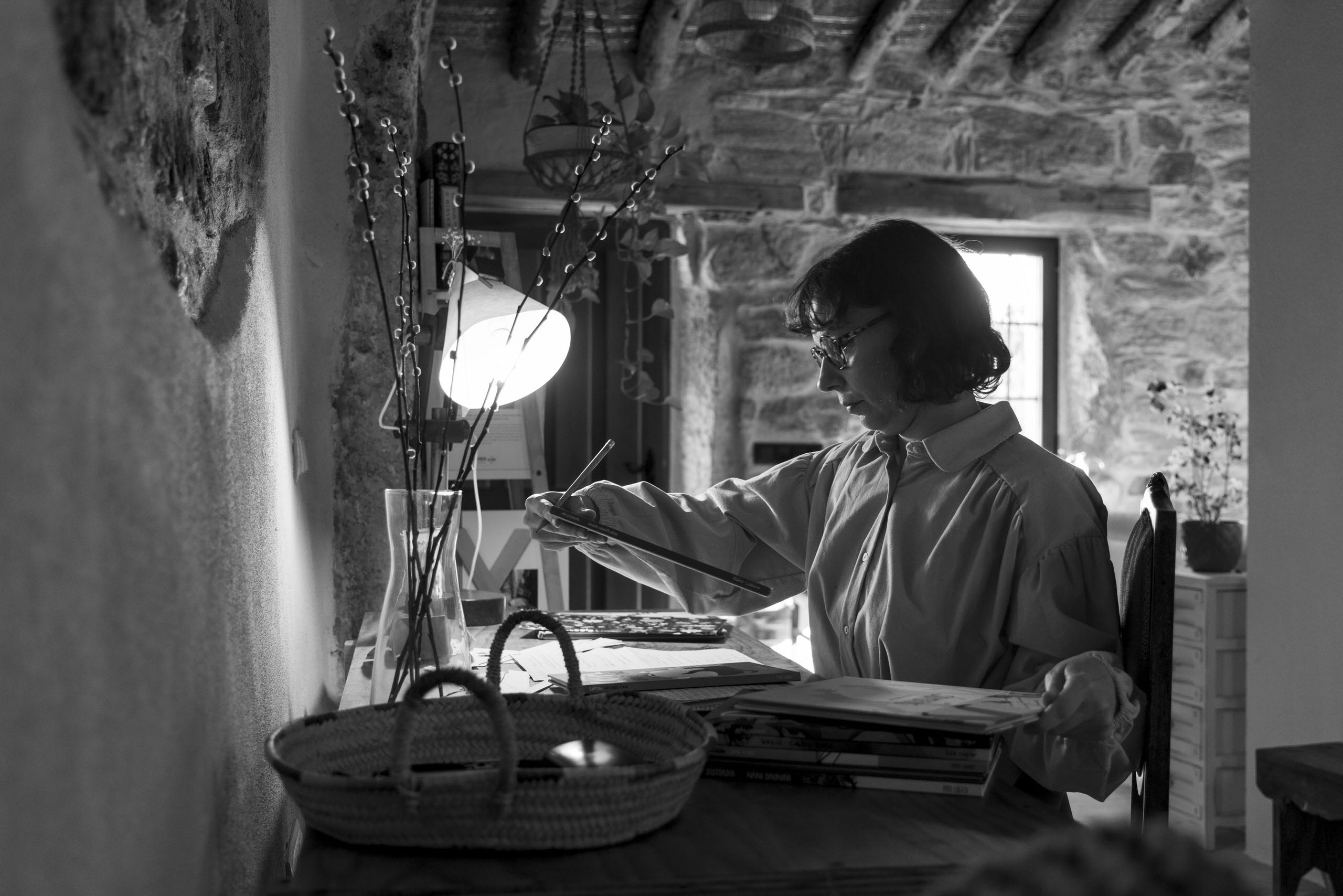 Mujer trabajando en ilustración y escritura en espacio creativo íntimo